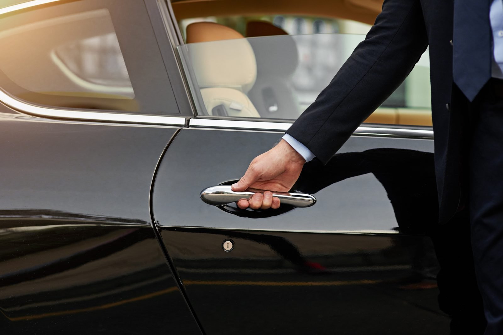 Professional chauffeur opening the door of a private transfer car in Albania