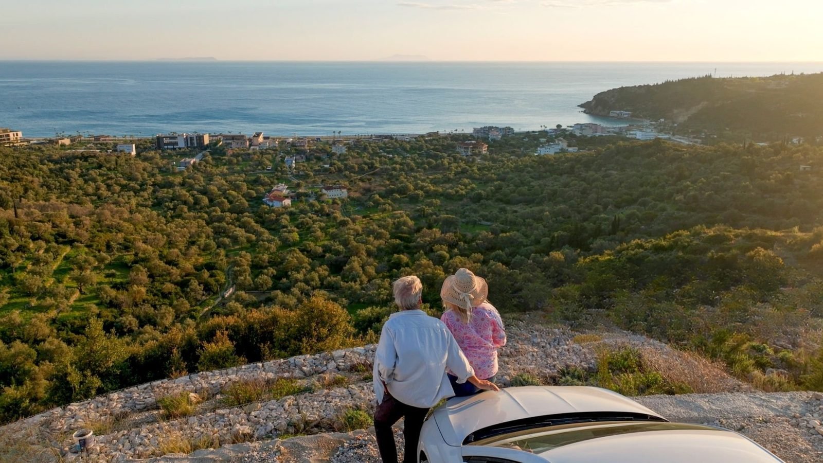Couple enjoying an Albanian Riviera viewpoint beside their private car