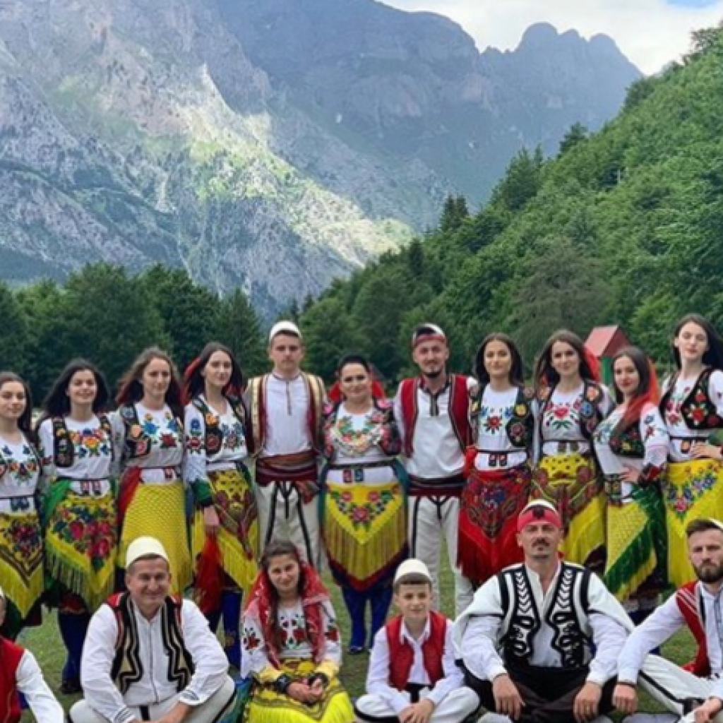 Albanian locals in traditional costumes at a cultural festival in northern Albania, showcasing the region's rich culinary and cultural heritage.